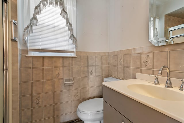 bathroom featuring vanity, toilet, and tile walls