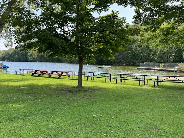 view of property's community with a water view and a yard