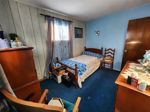 bedroom with dark carpet and wooden walls