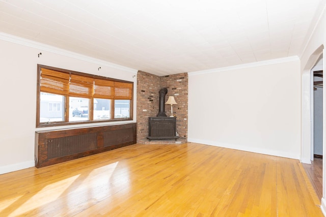 unfurnished living room featuring a wood stove, crown molding, radiator, and hardwood / wood-style flooring