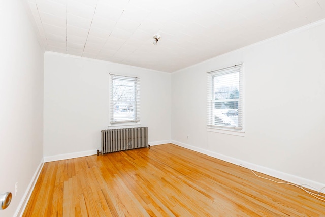 unfurnished room with hardwood / wood-style flooring, radiator heating unit, and ornamental molding