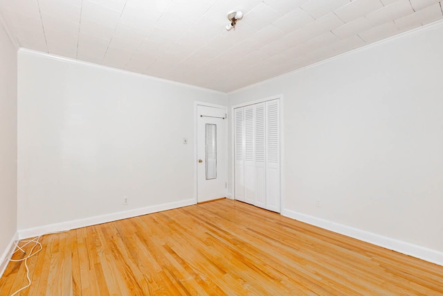 unfurnished room with hardwood / wood-style flooring and crown molding