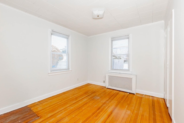 spare room with crown molding and hardwood / wood-style floors