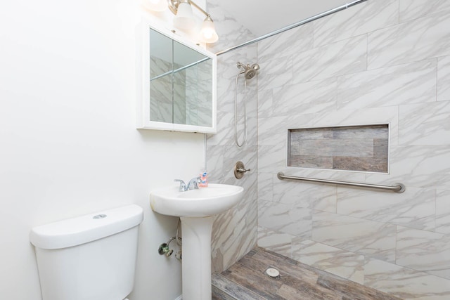 bathroom with toilet and a tile shower