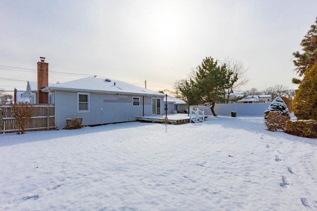 view of snow covered back of property