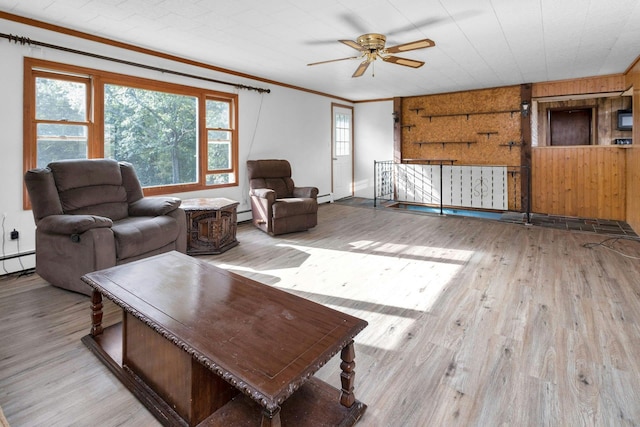 living room featuring light hardwood / wood-style floors, a baseboard heating unit, and crown molding