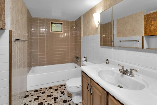 full bathroom featuring tile walls, toilet, vanity, and tiled shower / bath