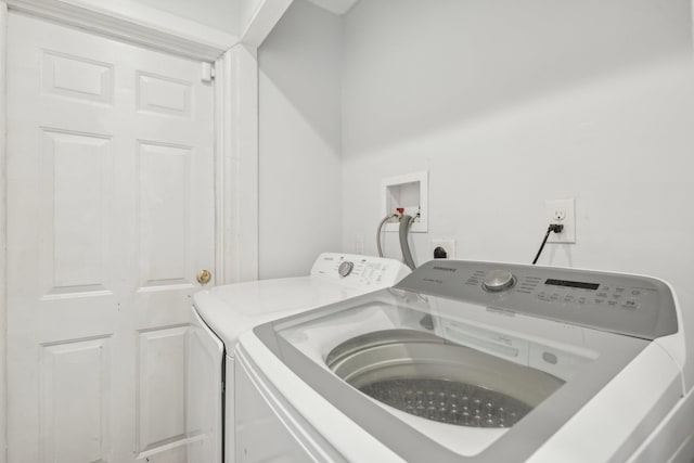 clothes washing area featuring separate washer and dryer