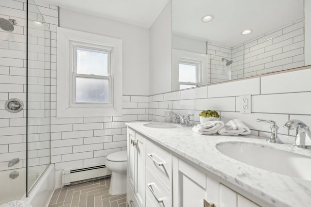 full bathroom featuring tiled shower / bath combo, tile walls, baseboard heating, tile patterned flooring, and vanity