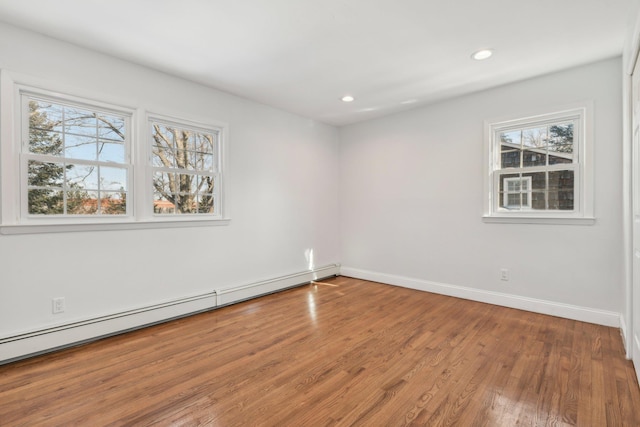 spare room with hardwood / wood-style flooring and a baseboard heating unit