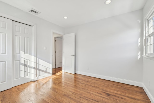 unfurnished bedroom with a closet and wood-type flooring