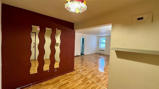 corridor featuring hardwood / wood-style flooring and radiator heating unit