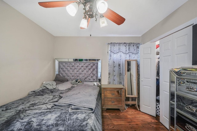 bedroom featuring dark hardwood / wood-style flooring, ceiling fan, and a closet