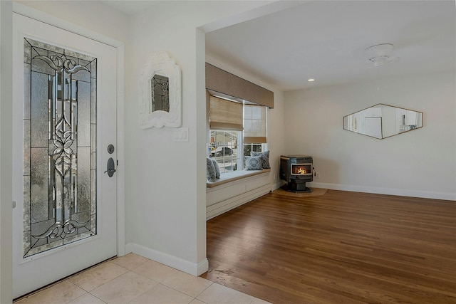 tiled entrance foyer featuring a wood stove