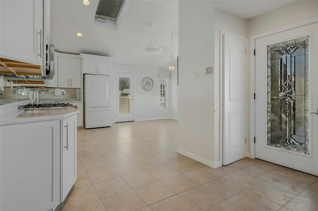 kitchen with white cabinetry, white fridge, and light tile patterned flooring