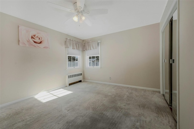 unfurnished bedroom with radiator, light colored carpet, and ceiling fan