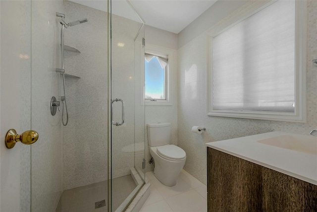 bathroom featuring tile patterned flooring, vanity, toilet, and walk in shower