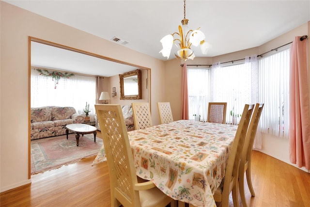 dining space featuring an inviting chandelier and light hardwood / wood-style flooring