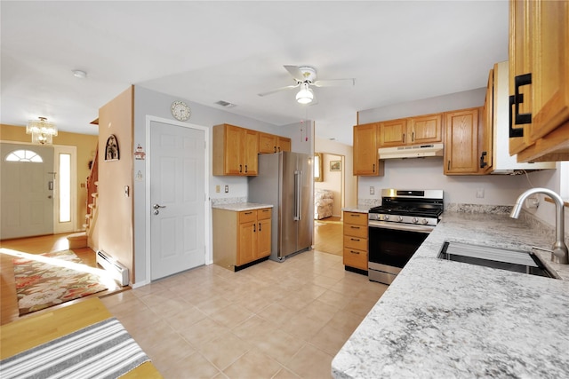 kitchen featuring appliances with stainless steel finishes, a baseboard radiator, sink, ceiling fan with notable chandelier, and light stone counters