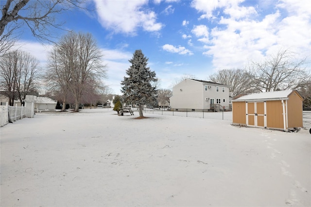 yard covered in snow featuring a storage unit