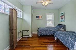 bedroom with multiple windows, dark hardwood / wood-style floors, and ceiling fan