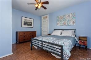 bedroom featuring ceiling fan and dark parquet flooring