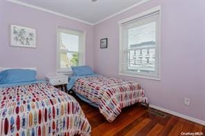 bedroom with ornamental molding and dark wood-type flooring