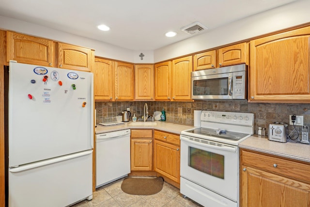 kitchen featuring sink, backsplash, white appliances, and light tile patterned flooring