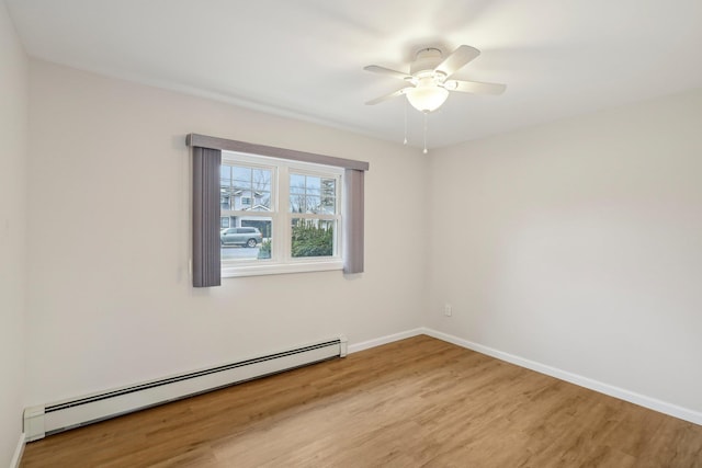 empty room featuring ceiling fan, light hardwood / wood-style flooring, and baseboard heating