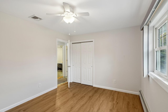 unfurnished bedroom featuring light wood-type flooring, a closet, multiple windows, and ceiling fan