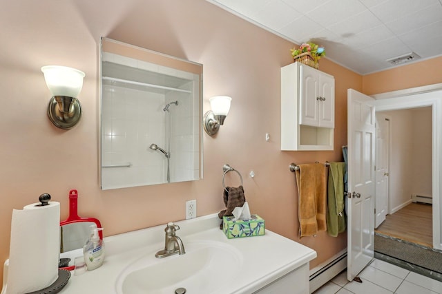 bathroom with tile patterned flooring, walk in shower, a baseboard heating unit, and vanity