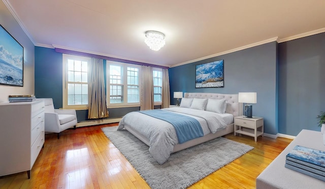 bedroom featuring a baseboard heating unit, crown molding, and wood-type flooring