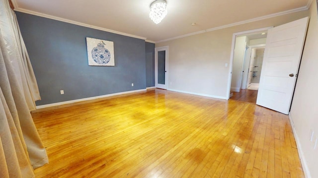 spare room featuring wood-type flooring and crown molding