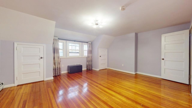 bonus room featuring a baseboard radiator and hardwood / wood-style floors