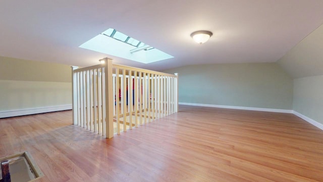 bonus room featuring light hardwood / wood-style floors and vaulted ceiling with skylight