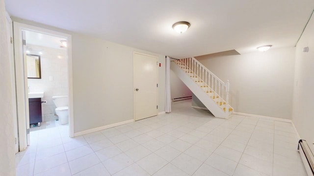 basement with a baseboard radiator and light tile patterned floors