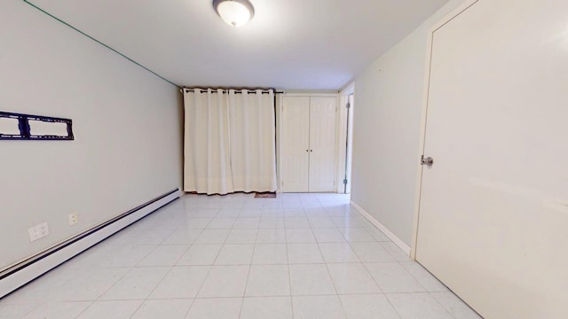 tiled empty room with a baseboard radiator