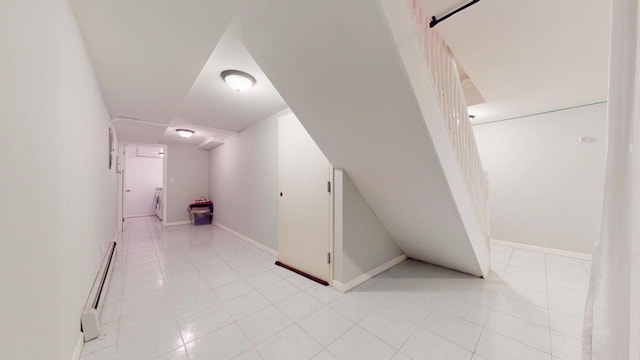 corridor with light tile patterned floors and baseboard heating