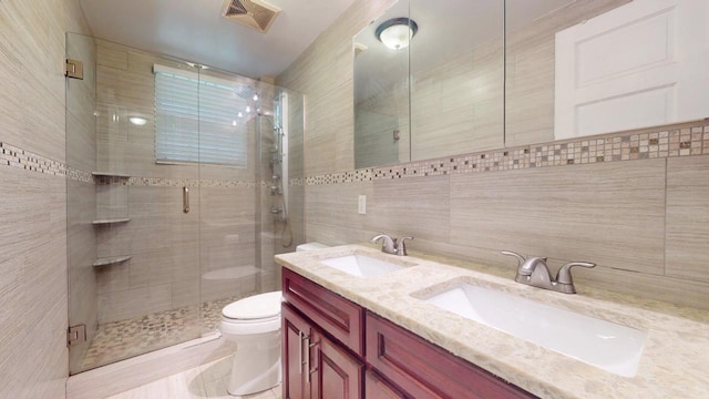 bathroom with tile walls, vanity, toilet, and walk in shower