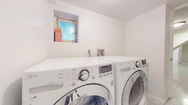 laundry room featuring light tile patterned floors and washing machine and dryer