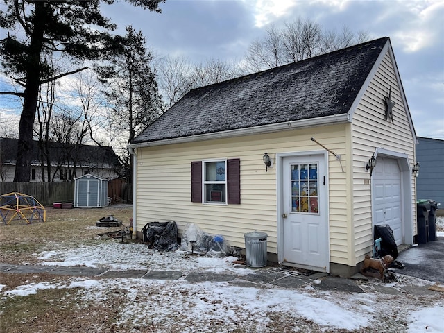 exterior space with a garage and a storage shed