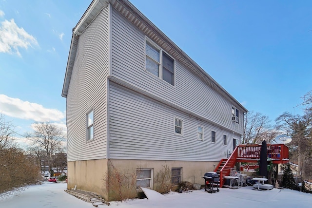 snow covered rear of property featuring a wooden deck