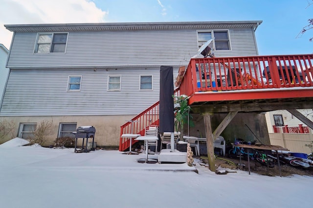 snow covered house featuring a deck