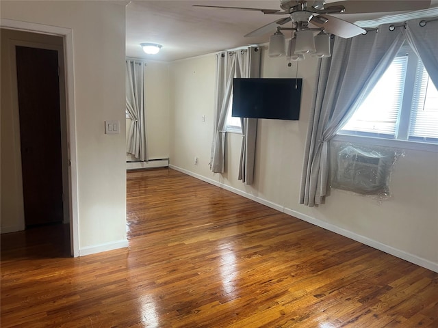 unfurnished living room with ceiling fan, hardwood / wood-style floors, and a baseboard heating unit