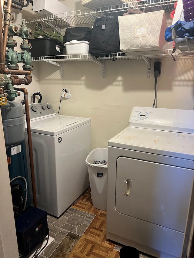 washroom featuring washing machine and dryer and dark parquet flooring