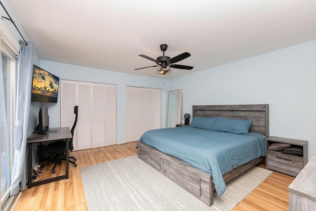 bedroom featuring light wood-style flooring, multiple closets, and ceiling fan