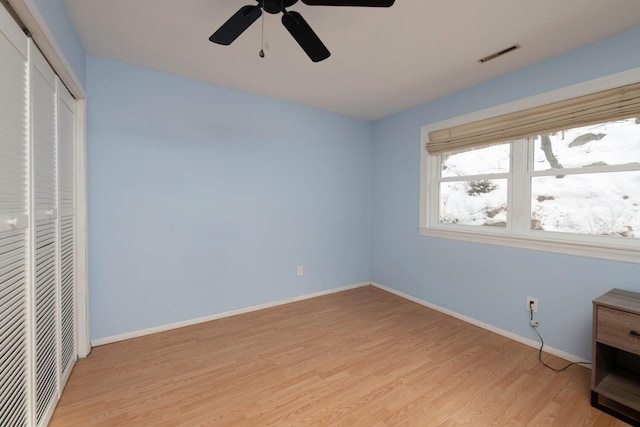 unfurnished bedroom featuring visible vents, baseboards, a closet, and light wood-style flooring