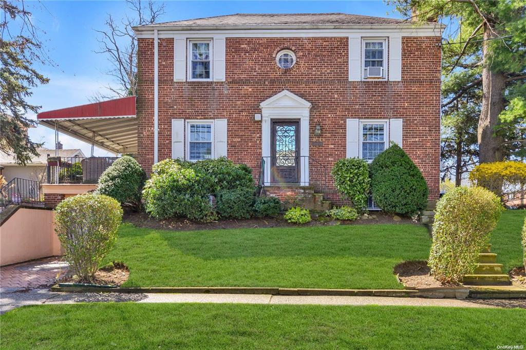 colonial-style house featuring a front lawn