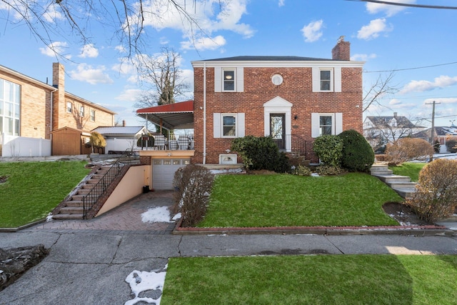 view of front of house featuring a garage, a front yard, and a storage shed