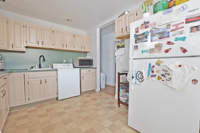 kitchen with sink, washer / dryer, and white fridge